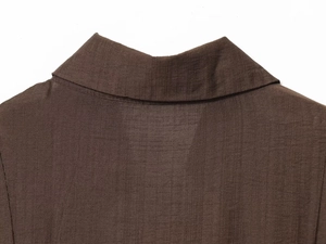 Gros plan du revers d'un blazer marron en tissu texturé avec détails de couture