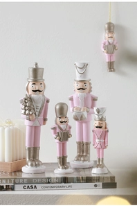 Pink and silver nutcracker soldier ornaments set displayed on decorative books