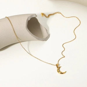 Macro shot of 18K gold plated moon pendant with sparkling cubic zirconia on a delicate chain