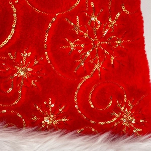 Detail of red plush fabric with gold sequin snowflake patterns and white faux fur trim