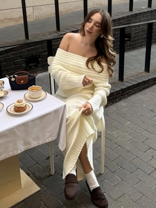 Close-up of cream white off-shoulder knit dress showing ribbed texture and elegant details