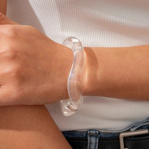 Detail of clear acrylic wave bracelet on wrist showing a transparent distorted texture