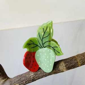 Pince à cheveux chic en acétate avec motifs de fraises rouges et vertes sur support bois