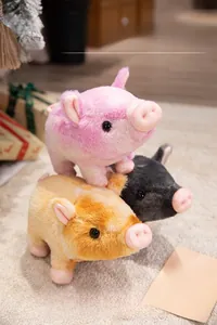 Détail de trois peluches cochons douces en couleurs rose, gris et marron foncé