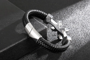 Macro detail of men's black braided leather bracelet with silver magnetic steel clasp