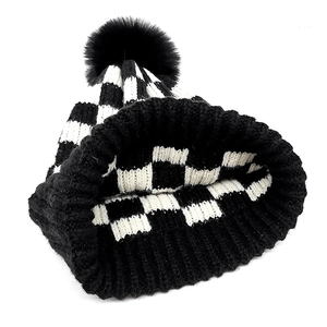 Classic checkered knit beanie with black pompom detail and ribbed cuff for winter warmth
