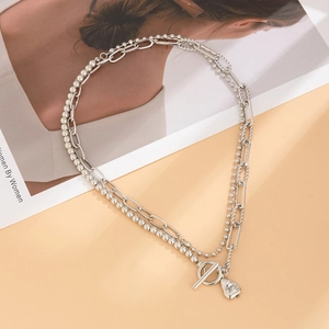 Detail of silver double-layer necklace with beads, T-bar clasp and small heart charm