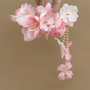 Detailed close-up of handmade pink fabric flower hair clip with elegant bead tassel