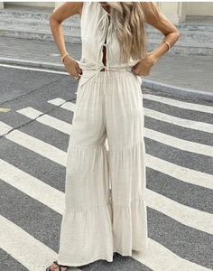 Detail of beige tie-up vest and layered wide-leg pants set in cotton linen fabric texture