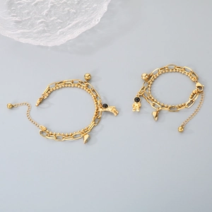 Close-up of golden double-layer chains with astronaut and heart charms for couples