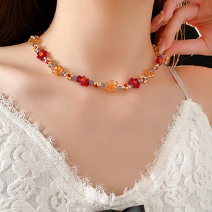 Gros plan du collier de fleurs colorées avec des perles en cristal rouge et bleu