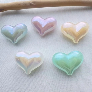 Macro view of colorful heart-shaped beads with pearlescent finish on a soft fabric