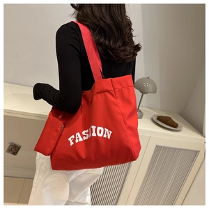 Macro view of red large capacity Oxford cloth tote bag with fashion letter print