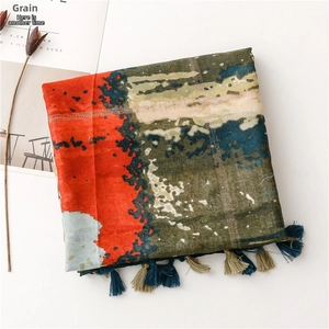 Détail d'écharpe artistique avec motifs abstraits, lignes dorées et glands à franges
