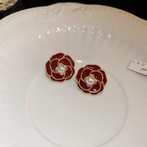 Detailansicht roter Kamelien-Ohrringe mit zentraler Perle und goldenem Metallrand