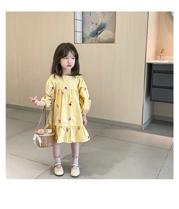 Détail de la robe jaune pour fille avec motif cerises rouges et ourlet à volants doux