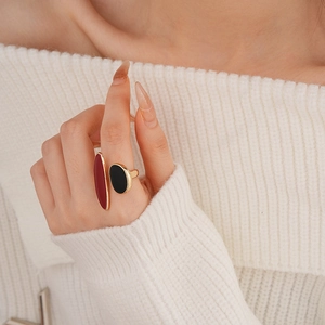 Close-up of gold drip glaze ring with red and black oval details on a model