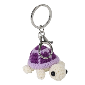 Handmade crochet turtle keychain with purple shell and cream body on a silver metal ring