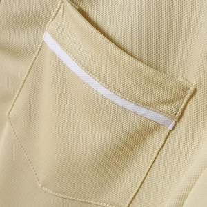 Dettaglio macro della tasca della polo beige con trama in tessuto piqué traspirante