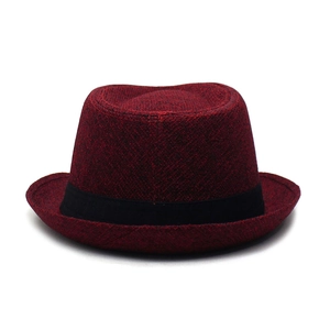 Detail of the wine red trilby hat showing textured fabric and black decorative ribbon band