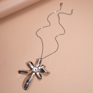 Macro shot of silver oversized floral pendant with irregular streamlined petals on a chain