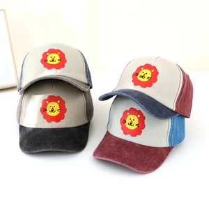 Dettaglio di cappellini da baseball per bambini multicolore con stampe di leoni e visiera in velluto