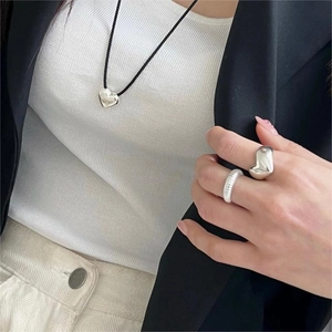 Detail of 925 sterling silver heart ring and striped textured ring on model