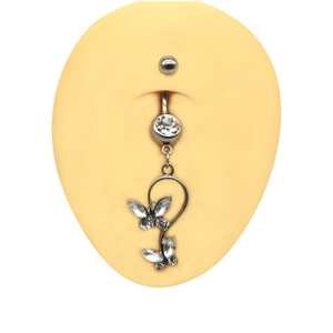 Piercing de nombril papillon argenté avec strass brillants sur modèle silicone