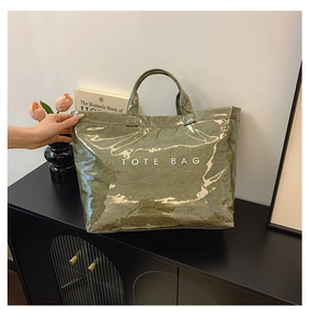 Detail of vintage green Tyvek tote bag with glossy texture and TOTE BAG lettering