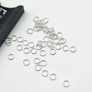 Silver jump rings for DIY jewelry making scattered on a clean white background