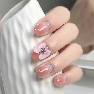 Pink gradient press-on nails with blue French tips, resin bows, and heart rhinestones