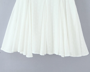 Dettaglio dell'orlo in pizzo bianco con ricami in stile broderie anglaise