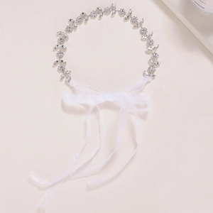Détail d'un bandeau de mariée avec fleurs en strass argentés et ruban de satin blanc