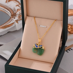 Elegant vintage green jade ruyi pendant necklace with gold chain in a velvet jewelry box