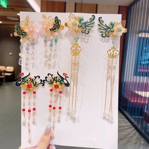 Detailed view of traditional gold flower hair clips with long tassels and enamel finish