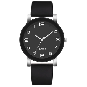 Détail d'une montre à quartz avec cadran noir, boîtier argenté et bracelet cuir