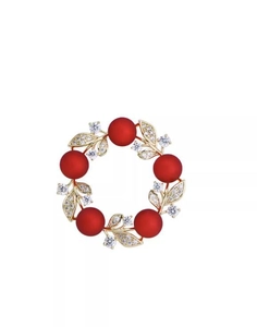 Detailed view of red pearl wreath brooch with gold leaves and shimmering crystals