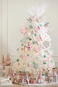 Pink and white candy ornaments on a white Christmas tree with festive holiday decor