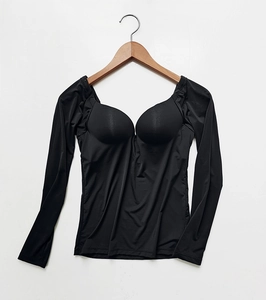 Detail view of a black long-sleeve bra top with built-in cups on a wooden hanger