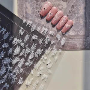 Detailed 5D relief nail stickers featuring white roses, bows, and crystal embellishments