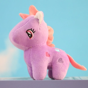 Macro view of purple plush unicorn pendant with pink mane and embroidered heart patterns