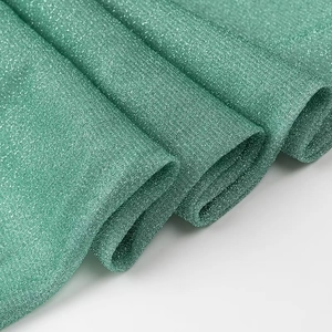 Vue détaillée du tissu plissé vert avec effet scintillant et texture fluide et douce