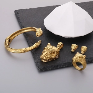 Macro detail of a 4-piece golden tiger head jewelry set including ring and bracelet