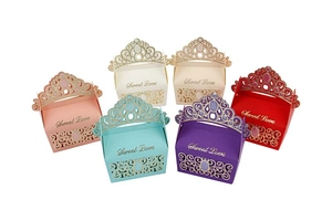 Macro shot of assorted crown laser-cut paper wedding favor boxes in six colors