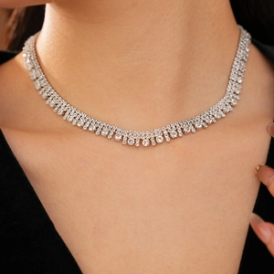 Primo piano della collana girocollo d'argento a più strati con nappe di zirconi su una modella