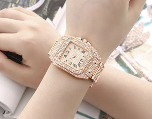 Close-up of gold square watch with crystal stones and Roman numerals on woman wrist