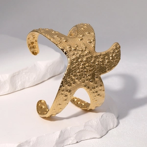 Minimalist 18k gold starfish open bangle bracelet with textured relief on white stone