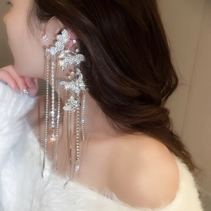 Detailed view of silver butterfly zircon tassel ear cuff on a female model