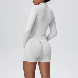 Vue latérale d'une veste en maille sans couture grise et de son short de fitness
