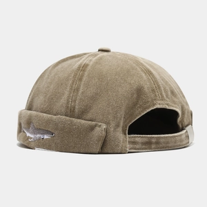 Detail of adjustable metal buckle and shark embroidery on washed khaki docker hat